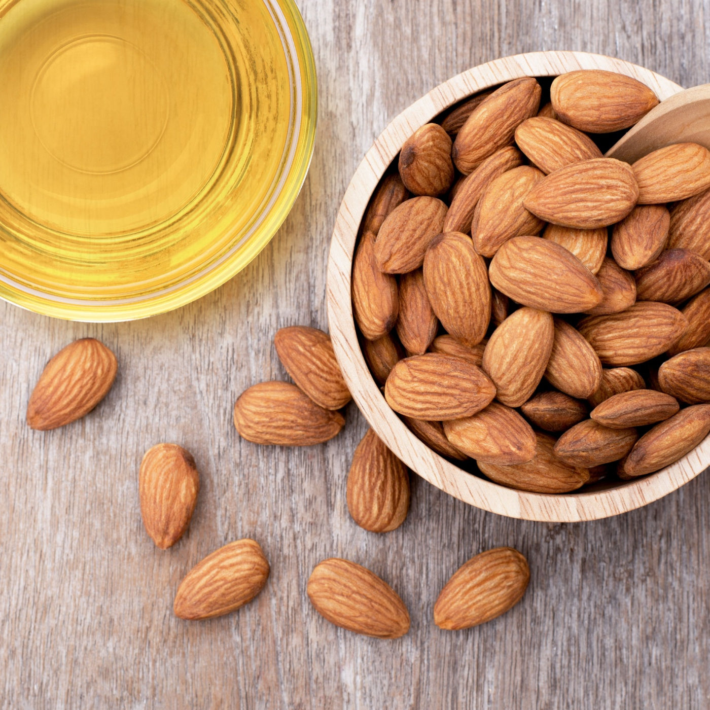 Sweet almond oil on a wooden table. Top view. 