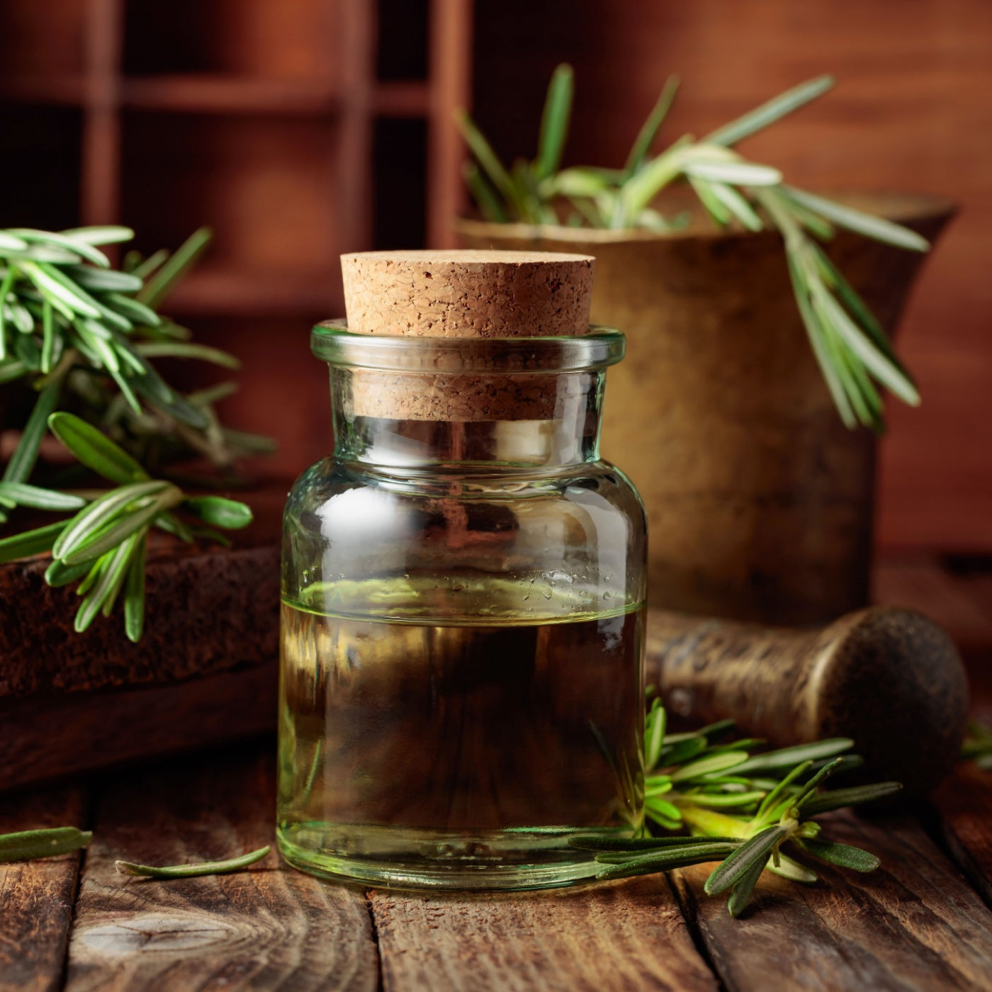 Rosemary essential oil or infusion on an old wooden table. 