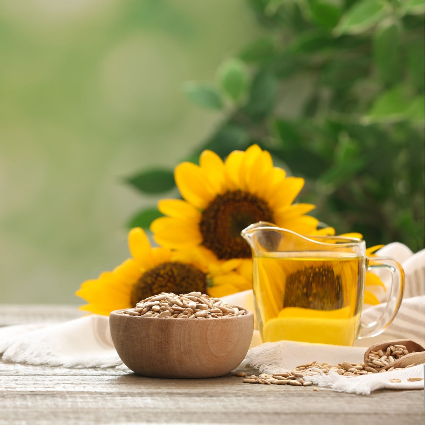 Sunflower oil and seeds on wooden table against blurred background.